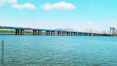 panorama view of the river, Yeouido Hangang River Park, in Seoul, Korea, with a broad bridge, and a cityscape in the backdrop 