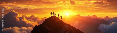 Silhouetted hikers atop a peak at sunset, vibrant sky and mountains create a breathtaking view.