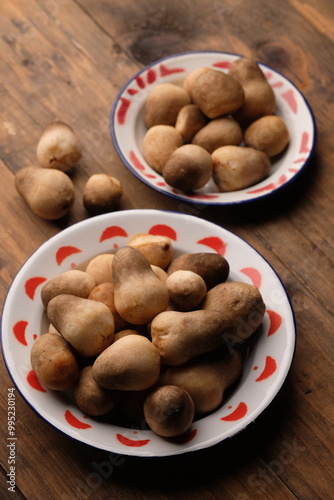 Volvariella volvacea is a species of edible mushroom cultivated throughout East and Southeast Asia and used extensively in Asian cuisines. straw mushroom in wooden box. jamur merang.  photo