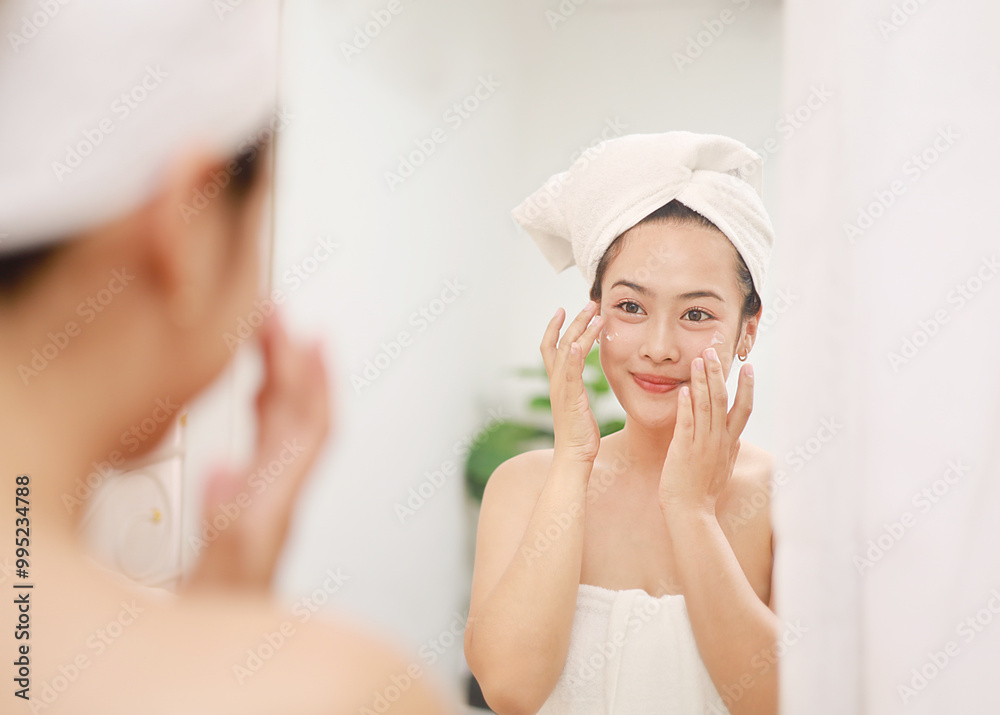 Skin care beauty on face, smiling beautiful asian woman in bathrobe looking in mirror and using serum cream to nourish skin in daily life. Skin care beauty on face, smiling beautiful asian woman in bathrobe looking in mirror and using serum cream to nourish skin in daily life.