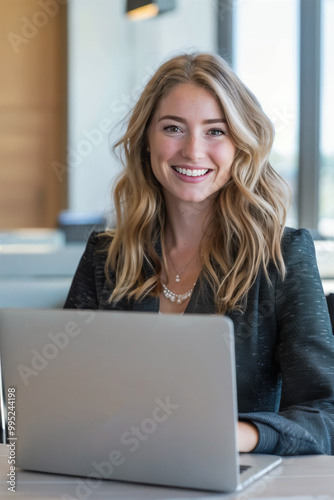 A Young, Happy, and Successful Businesswoman Working with a Laptop in a Corporate Office.