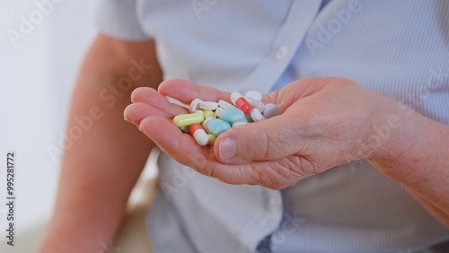 Close up of senior woman's hand with lots of drugs, alzheimer syndrome medicine treatment