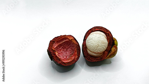 Ripe mangosteen fruit (Garcinia Mangostana Linn) with dark purple skin, revealing the fresh, white interior of the fruit, isolated on a white background. photo