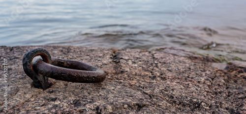Old rusty mooring ring in rock near lake Vattern Motala Sweden
