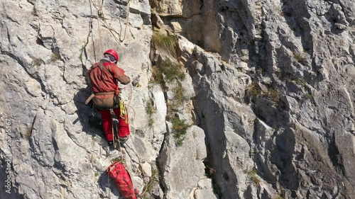 Aerial view of mountain rescuer doing rescue operations hanging on a rope