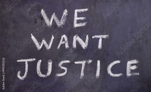 We Want Justice Slogan Written on Blackboard with White Chalk