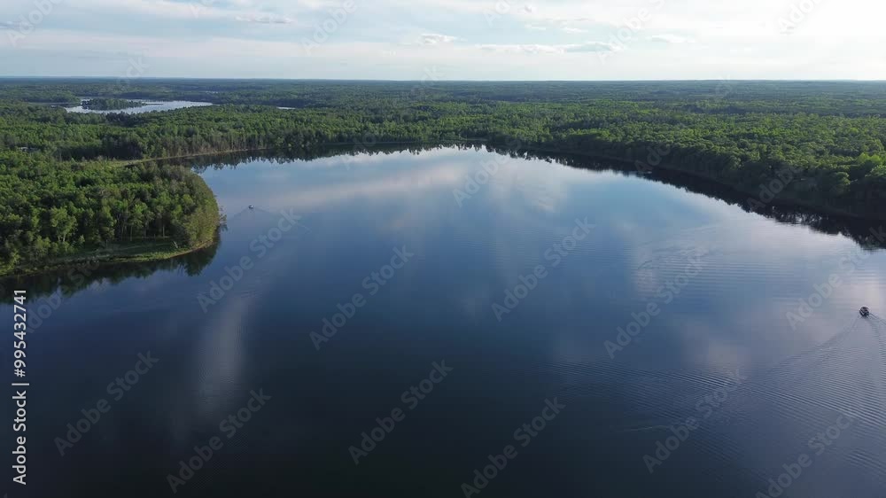 Drone shot over large lake in Northern Wisconsin surrounded by trees Drone shot over large lake in Northern Wisconsin surrounded by trees