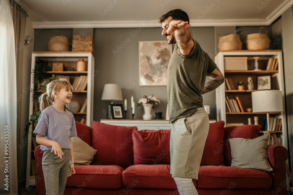 Father and his little daughter dancing and having fun during their time at home together Father and his little daughter dancing and having fun during their time at home together