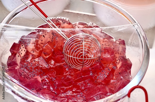 Sweet and delicious grape flavored agar-agar fruit cubes jelly dessert toppings in glass bowl with plastic cover isolated on horizontal ratio white table background. photo