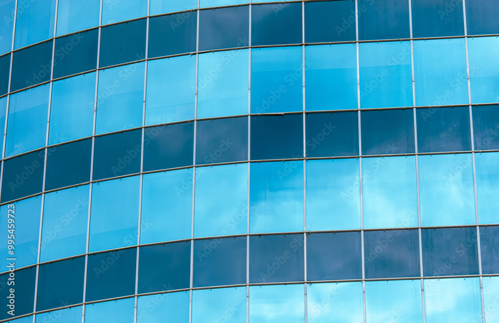 A blue building with many windows and a cloudy sky in the background A blue building with many windows and a cloudy sky in the background