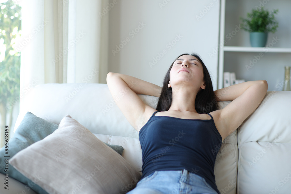 Asian woman relaxing and resting sitting on a sofa Asian woman relaxing and resting sitting on a sofa
