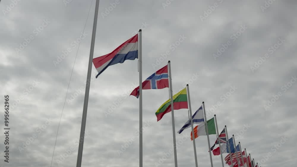 A row of flags from different countries are flying in the sky. The flags are of various colors and sizes, and they are arranged in a neat row. Concept of unity and diversity