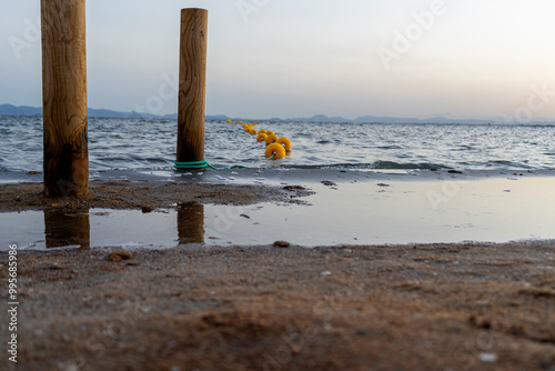 Yellow bollards, signaling bathing area. photo