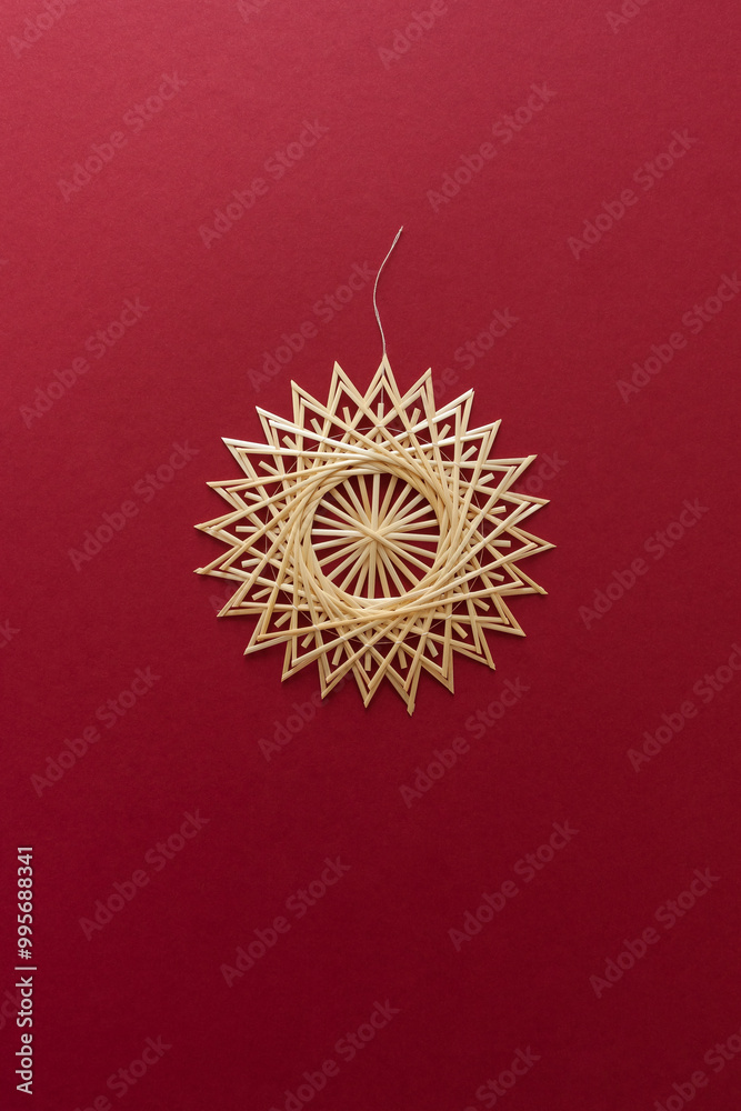 Snowflakes are made of straw on a red background. Christmas decor. Straw star. Top view. Straw weaving. Lutsk, Ukraine Snowflakes are made of straw on a red background. Christmas decor. Straw star. Top view. Straw weaving. Lutsk, Ukraine
