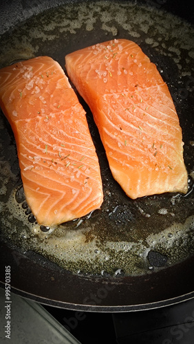 morceaux de saumon en cuisson dans une poêle photo