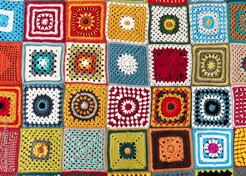 Rainbow colored granny squares background. Handmade crocheting, needlework and handicraft concept. Lay flat. 