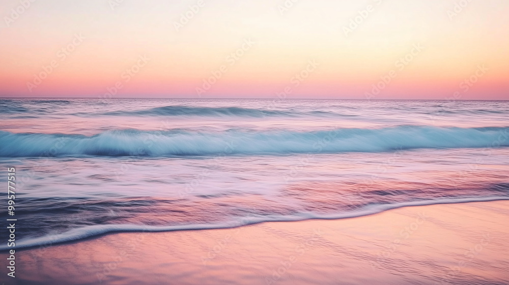 Beautiful beach sunset with rolling waves and smooth water in pastel pink and blue hues Beautiful beach sunset with rolling waves and smooth water in pastel pink and blue hues