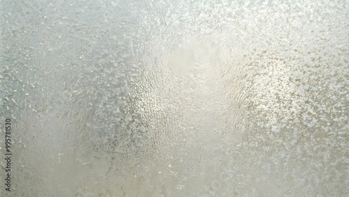 Frosted Glass Texture: An abstract background featuring a frosted glass surface with a subtle pattern of tiny bubbles. The image conveys a sense of privacy, mystery, and ethereal beauty.