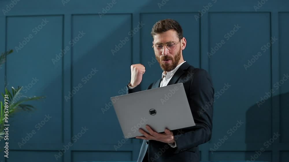 Businessman works on a laptop. He succeeded internationally by winning big contract.He`s very happy