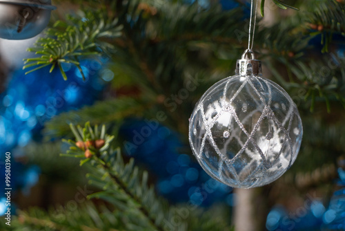 Silvery Christmas ball, blue tinsel on a Christmas tree