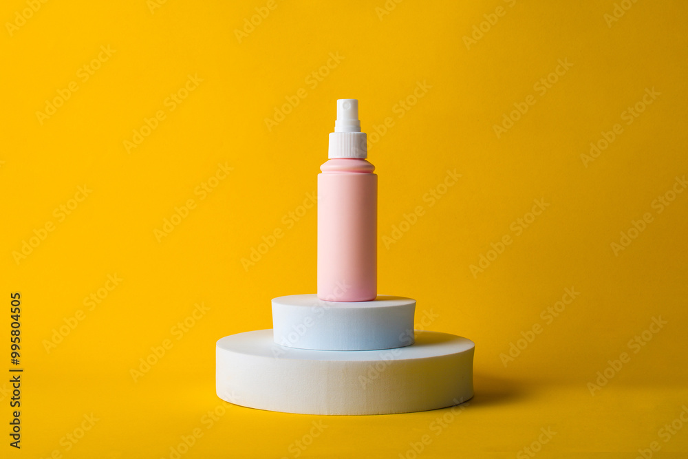 Cosmetic pink bottle, bottle, lotion or serum with stylish props on yellow background. Cosmetic pink bottle, bottle, lotion or serum with stylish props on yellow background.