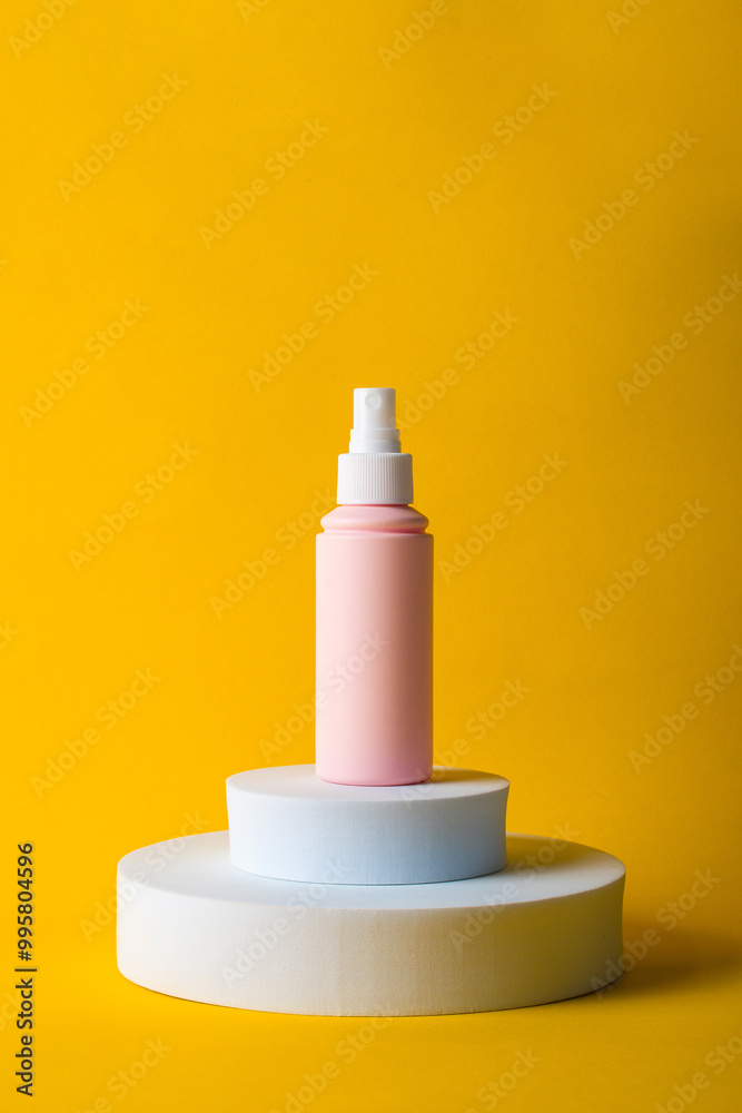 Cosmetic pink bottle, bottle, lotion or serum with stylish props on yellow background. Cosmetic pink bottle, bottle, lotion or serum with stylish props on yellow background.