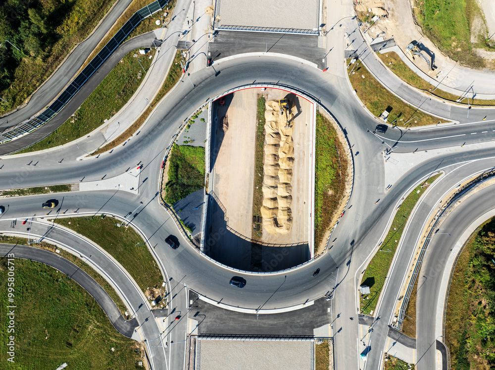 Krakow, Poland. Wegrzce highway interchange in construction on S53, part of motorway ring way around Cracow. Traffic circle with a hole inside, viaducts, tunnels and ramps. September 2024. Aerial view