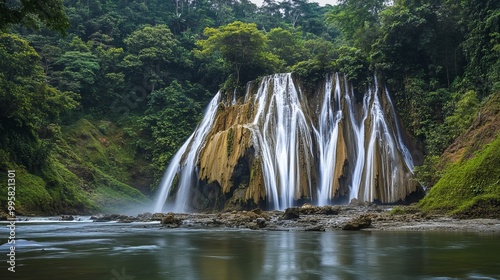 Sri Gethuk Waterfall cascades gracefully down the rocky cliffs at Oyo River, located in Menggoran Village, Yogyakarta Province, Central Java, Indonesia. photo