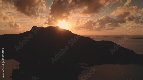 Stunning sunrise over mountain peak, warm hues sky over ocean lagoon Bora Bora island in French Polynesia. Serene idyllic exotic paradise, ideal peaceful getaway. Nature background. Aerial drone shot photo