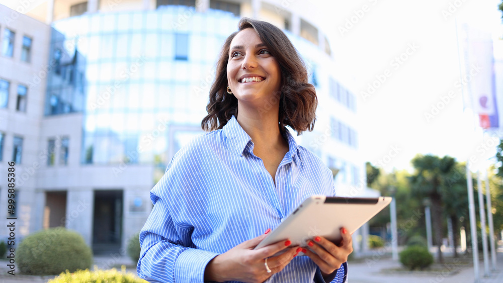 Fototapeta premium Beautiful, young businesswoman using a digital tablet and enjoying in the city