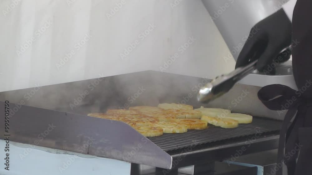 cook preparing and frying food on the grill