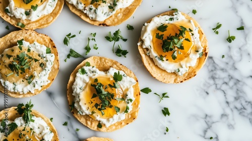 Overhead view of tostadas with goat cheese and honey, set on marble, evokes a Mediterranean vibe.