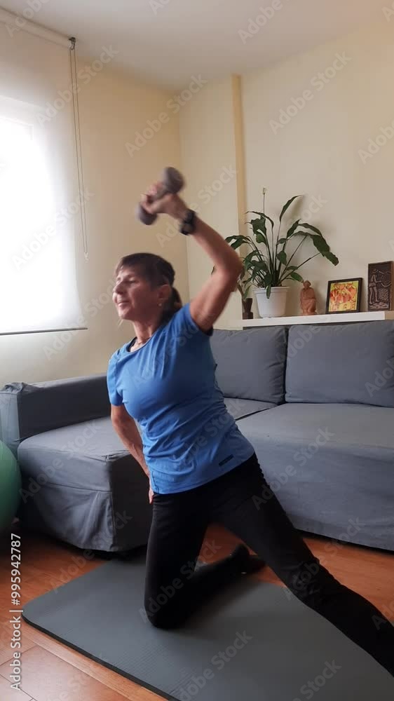 Middle-aged woman doing exercises at home with ball and weights. Middle-aged woman doing exercises at home with ball and weights.
