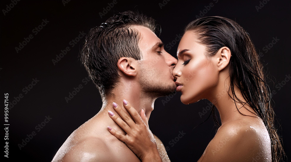 Couple with dark eyes, wet hair, wet bodies, love kissing, black background, fashion photo Couple with dark eyes, wet hair, wet bodies, love kissing, black background, fashion photo