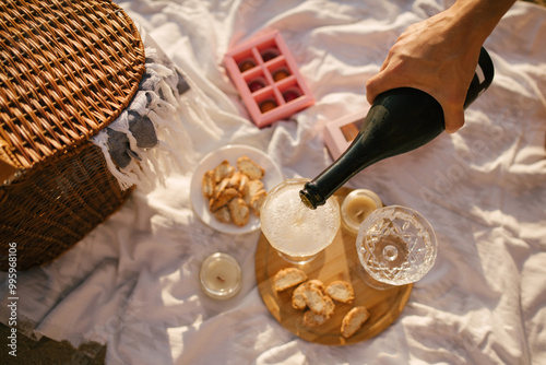 Beautiful summer picnic with champagne at sunset on the beach.