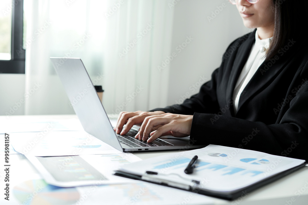 Asian businesswoman sit at their desks and calculate financial graphs showing results about their investments and plan successful business growth process Asian businesswoman sit at their desks and calculate financial graphs showing results about their investments and plan successful business growth process