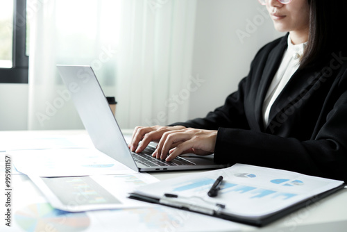 Asian businesswoman sit at their desks and calculate financial graphs showing results about their investments and plan successful business growth process