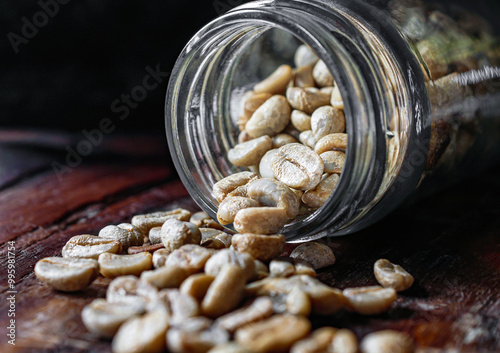 Green coffee beans poured out of a glass jar, Close-up of green raw coffee bean, unroasted coffee bean photo