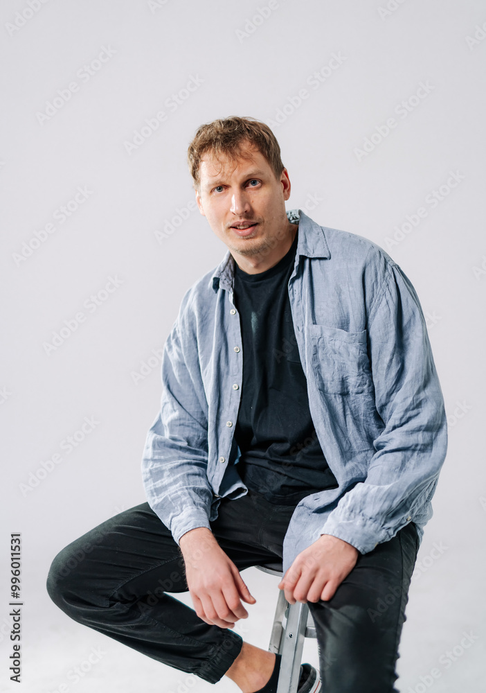 Young man on stool in studio session. Young man on stool in studio session.
