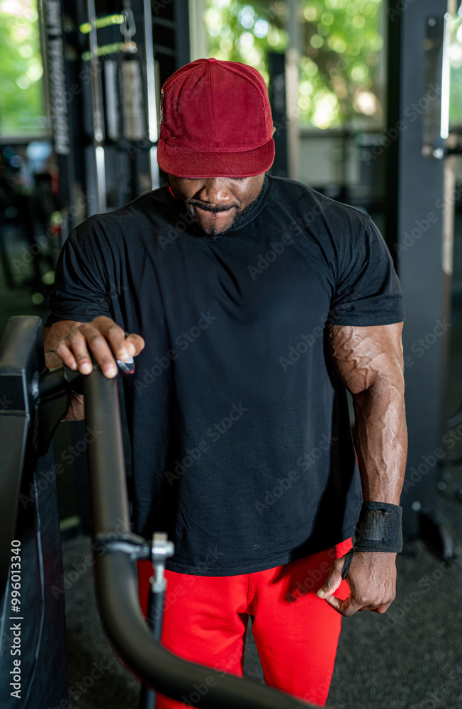 Muscular man exercising in gym during daytime. Muscular man exercising in gym during daytime.
