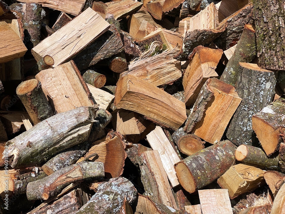 Firewood background concept: a pile of chopped oak wood ready to be used in wood stoves and fireplaces