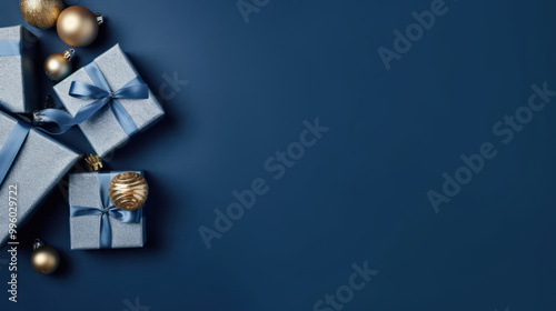 Top view of gifts, bows and Christmas decorations on a indigo background