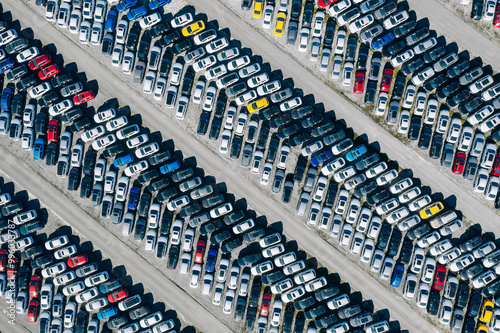 Fototapeta Naklejka Na Ścianę i Meble -  Aerial drone view of Parking lot. New cars storage area. Many cars parked in a rows