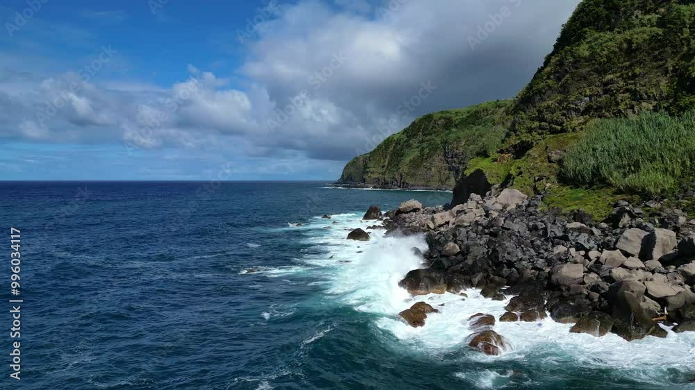 Aerial drone view of a beautiful rocky coastline. Camera flies low along volcanic rocks, Atlantic Ocean waves and cliffs. Near Salto da Farinha viewpoint, Sao Miguel Island, Azores, Portugal Aerial drone view of a beautiful rocky coastline. Camera flies low along volcanic rocks, Atlantic Ocean waves and cliffs. Near Salto da Farinha viewpoint, Sao Miguel Island, Azores, Portugal