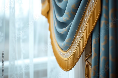 Elegant blue curtain with golden fringe hanging by the window