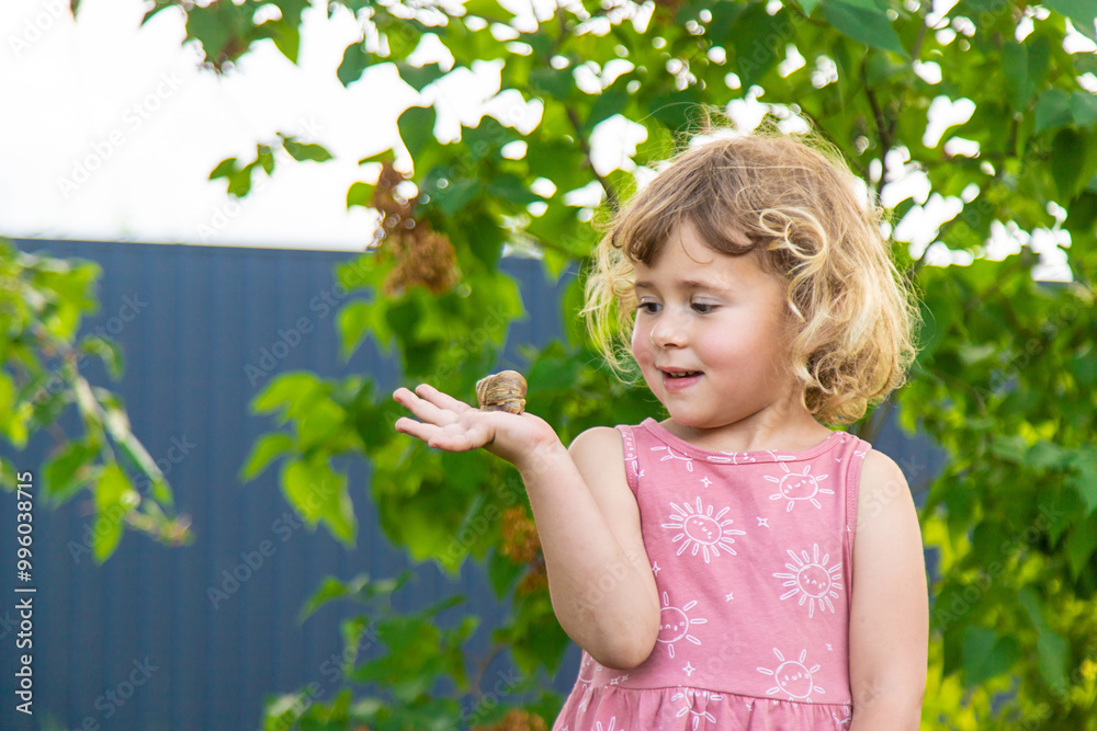 Child holding a snail on his hand. Selective focus. Child holding a snail on his hand. Selective focus.
