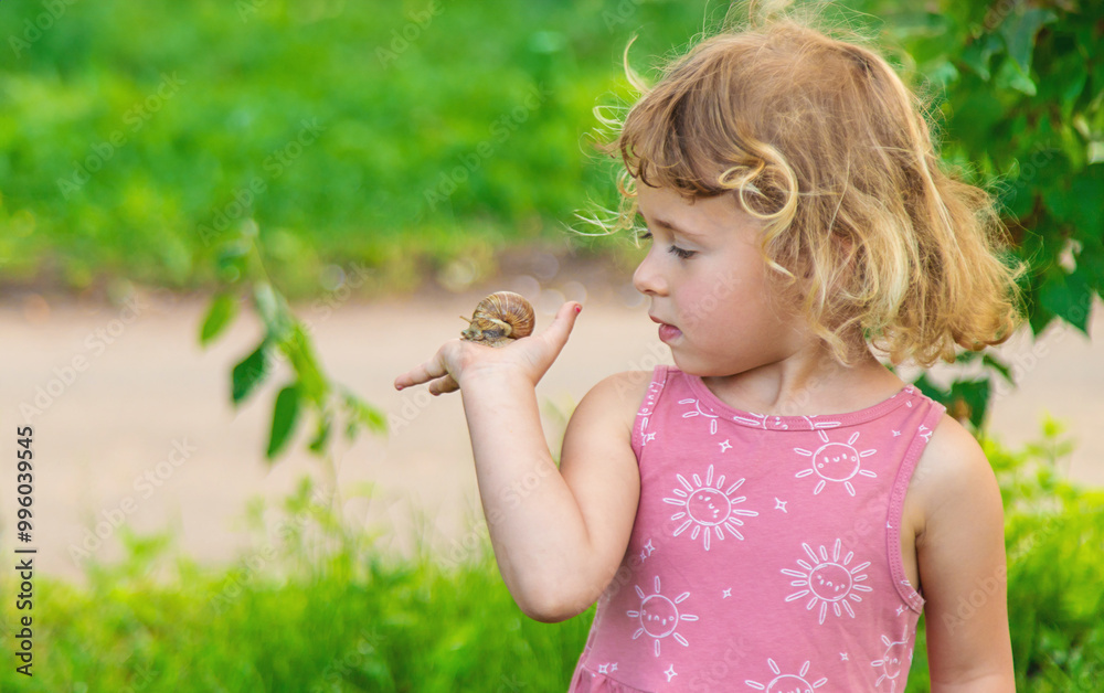 Child holding a snail on his hand. Selective focus. Child holding a snail on his hand. Selective focus.