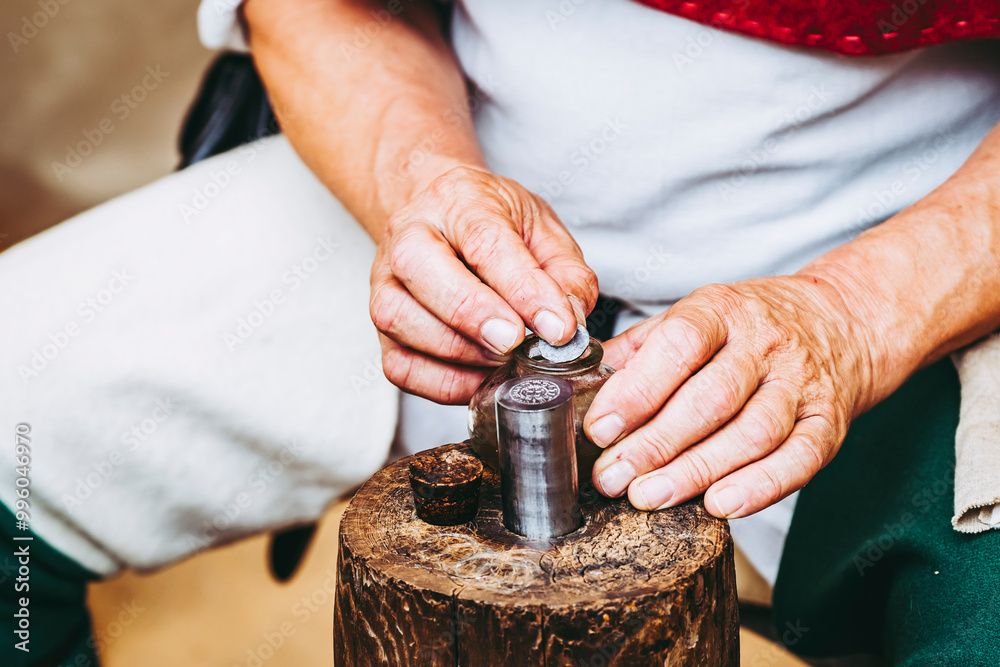 Main d'un artisan en train de fabriquer des pièces de monnaie en métal à l'ancienne