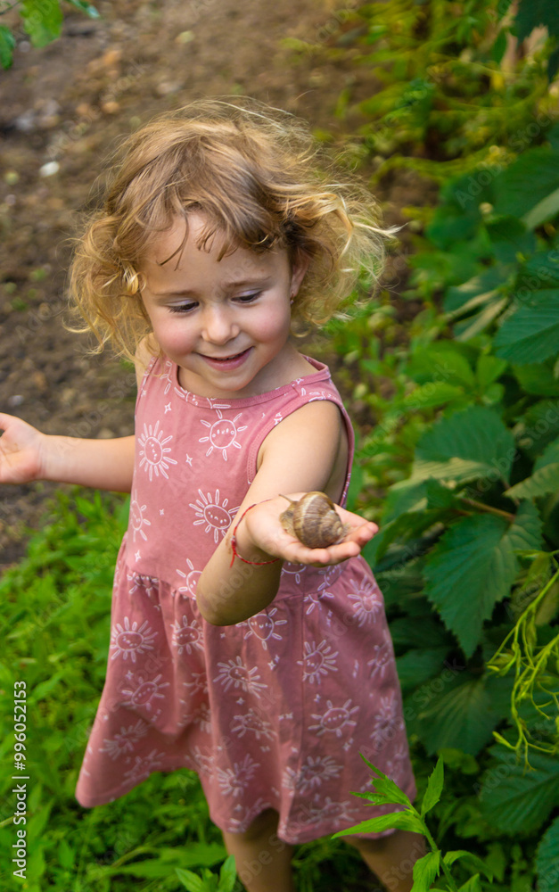 Child holding a snail on his hand. Selective focus. Child holding a snail on his hand. Selective focus.