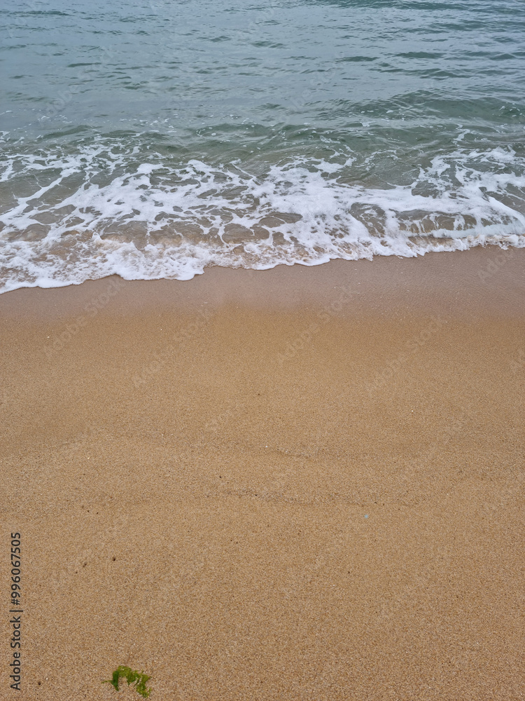 It is a beach with waves crashing in It is a beach with waves crashing in